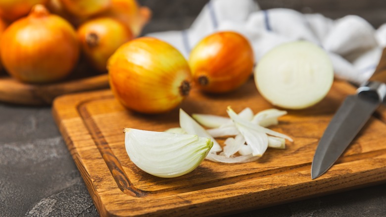 onions on a kitchen table and sliced on a cutting board