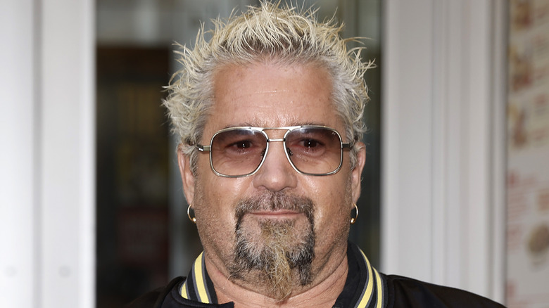 Guy Fieri wearing sunglasses and looking directly at the camera.