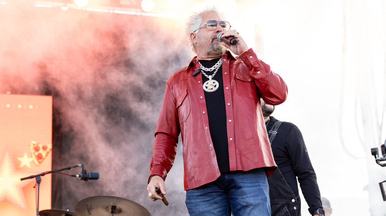 Guy Fieri on stage with smoke in the background