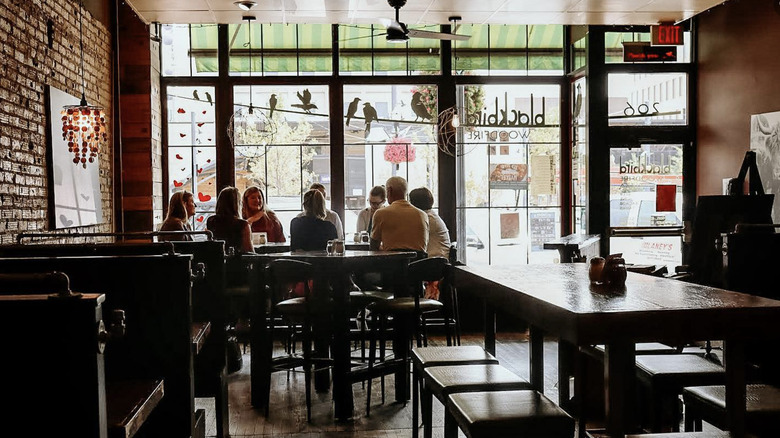 People sit at a table inside Blackbird Woodfire