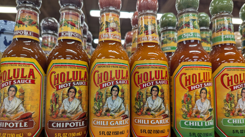 A variety of Cholula hot sauces on a grocery store shelf.