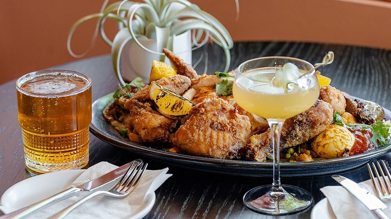 Two cocktails and a plate of fried food at Joya's