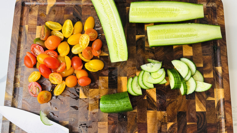 Cucumbers and cherry tomatoes on a cutting board