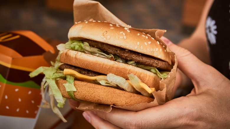 A Big Mac in a customer's hand at McDonald's