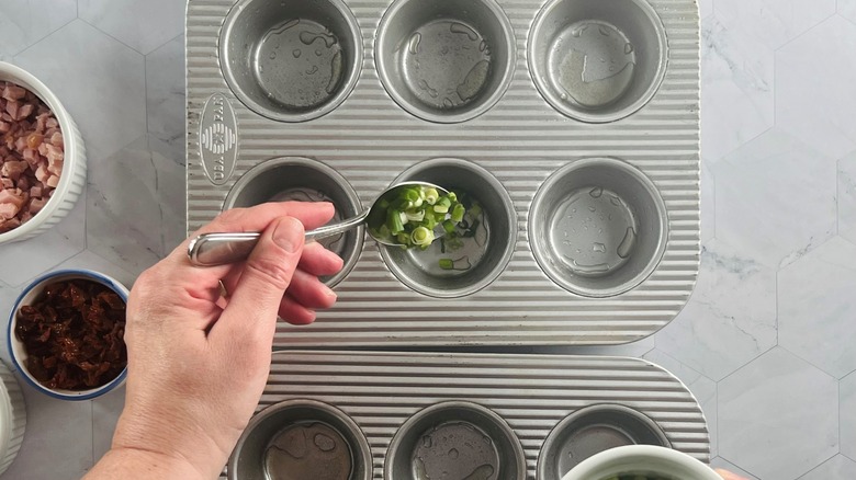 hand putting onions in pan