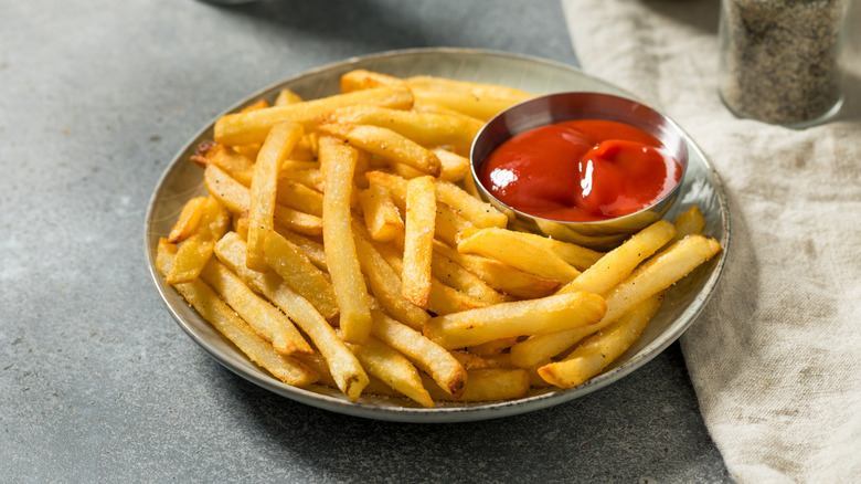 a plate of fries with ketchup