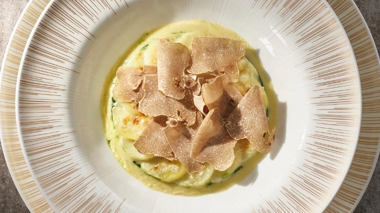 Yukon Potato Gratin "Florentine" with Gorgonzola Dulce, Parmesan, and Tartuffi di Alba on a decorative white plate