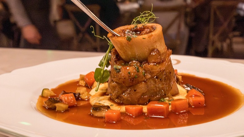 Braised beef shank with demi glace on a white plate