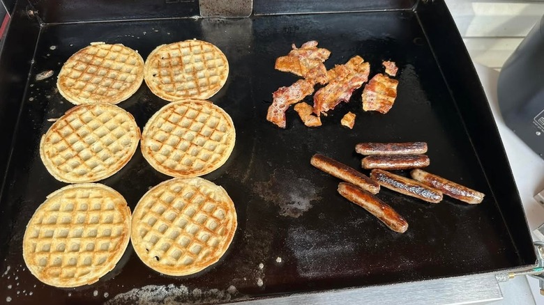 Waffles, sausage, and bacon on a griddle