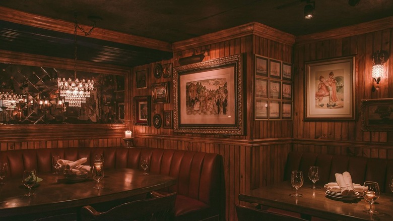 The interior of 4 Charles, with dark wood and old school chandeliers