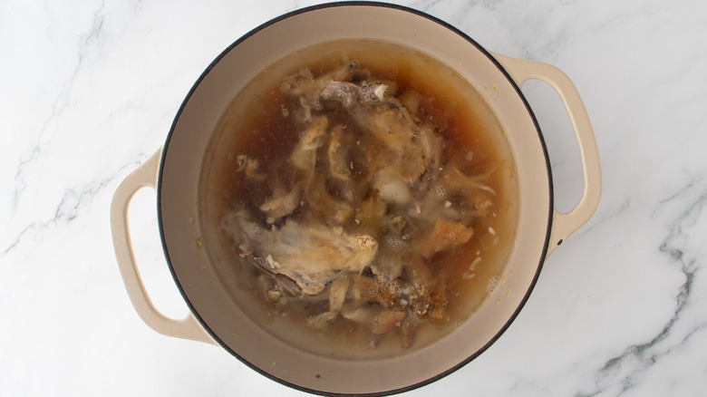 chicken bones and skin in a pot of water