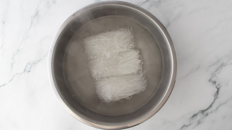 noodles in a metal bowl filled with water