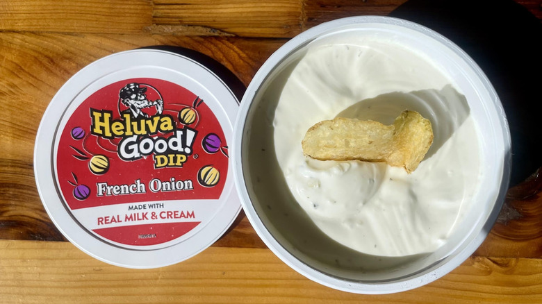 Overhead view of open container of Heluva Good! French Onion Dip on wooden tabletop