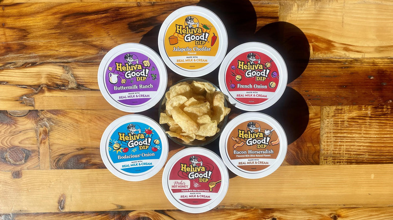 Overhead view of six Heluva Good! Dips with a bowl of potato chips in the center