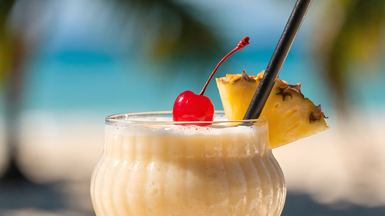 the top of a frozen pina colada garnished with pineapple and cherry.