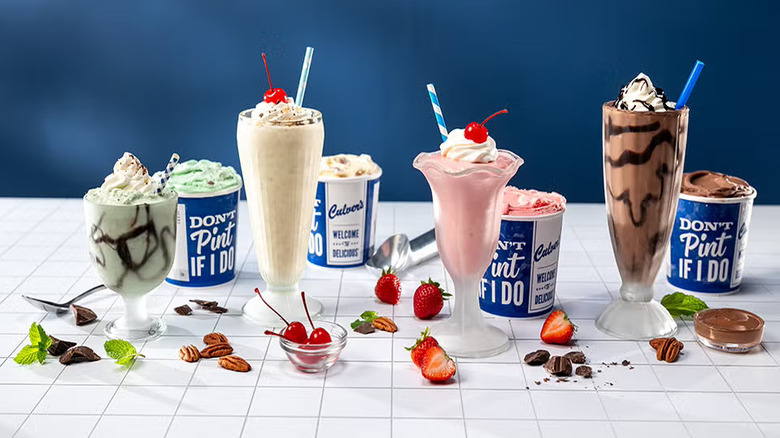 Culver's custard pints and cups in a variety of flavors with mix-ins scattered on a white table