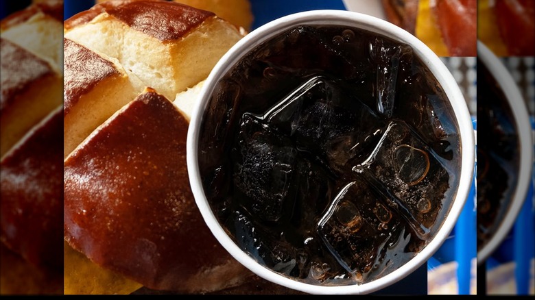 Customer drinking a Culver's beverage from a paper cup with blue straw