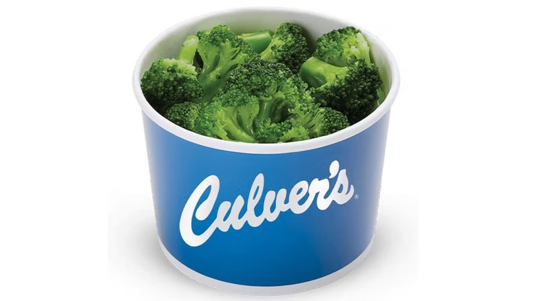 Cup of steamed broccoli in a blue and white Culver's cup on a white background