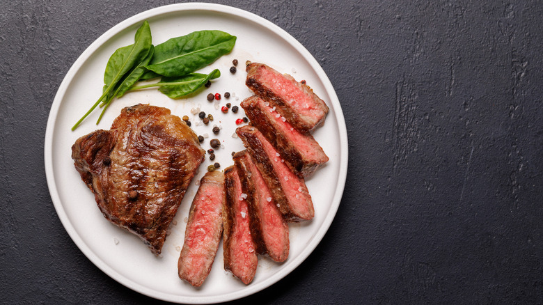 Sliced steak on white plate