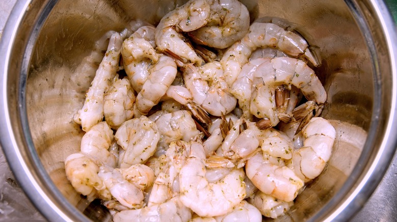 raw peeled shrimp being velveted in a bowl