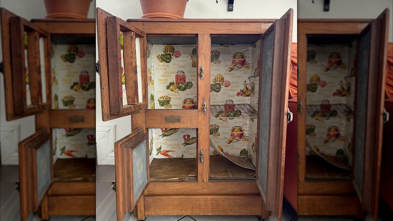 a 1920s-era icebox with doors opened, showing food-themed papering and a rack where food would go