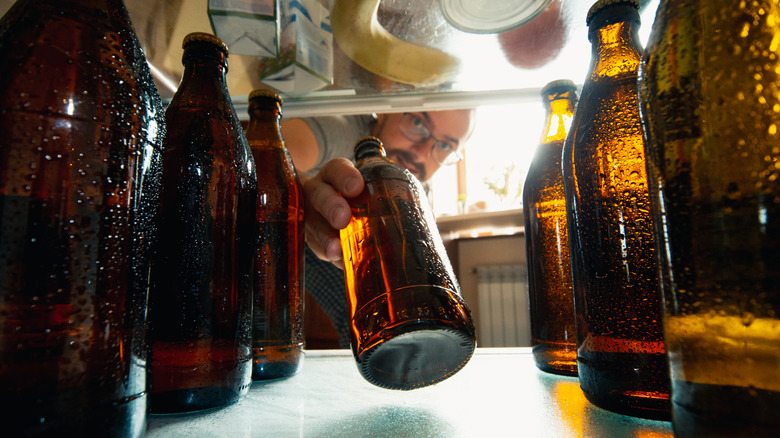 Person taking a beer bottle out of the fridge