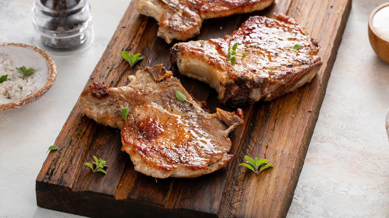 Pork chops on wooden board