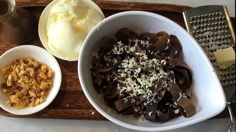 Dessert with chocolate pasta, ice cream, white chocolate, and nuts