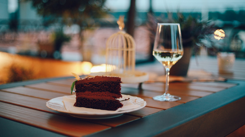chocolate cake with glass of white wine on outdoor table