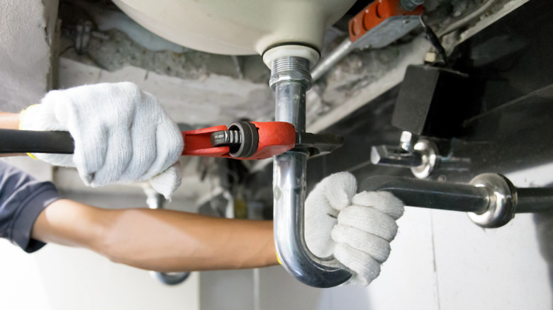 Plumber fixing clogged sink