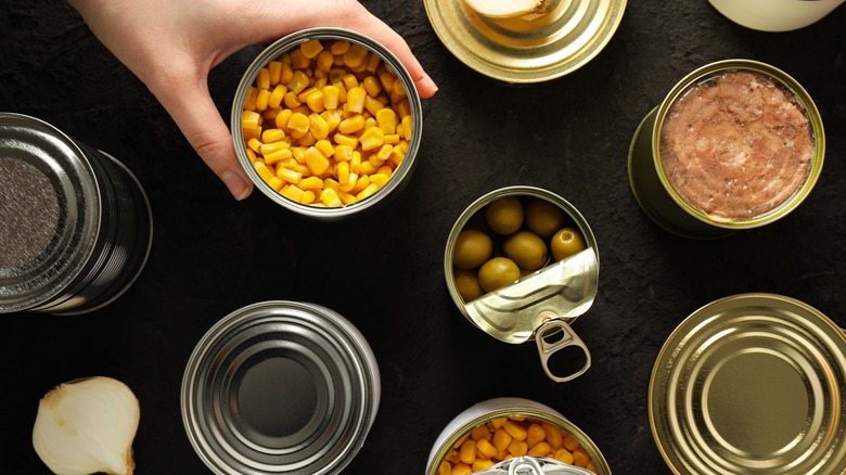 Cans with food, on a dark background.
