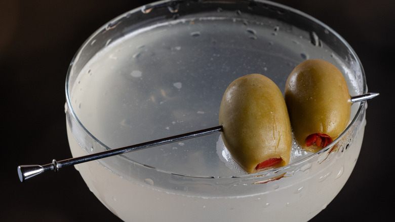 A bruised martini finished with two olives