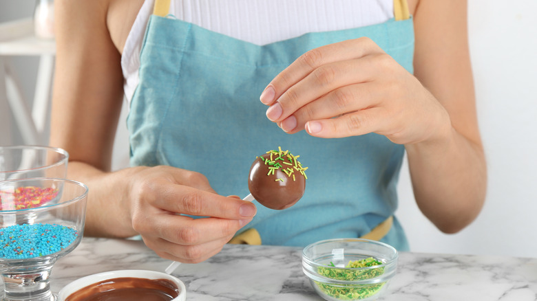 Woman making a cake pop.