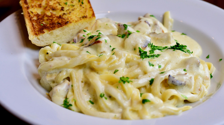 Delicious Fresh and Creamy Pasta at a Restaurant with crispy golden bread.