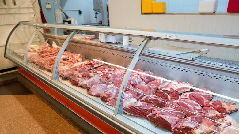 Various raw beef cuts sit in a display case at the butcher shop inside a supermarket.