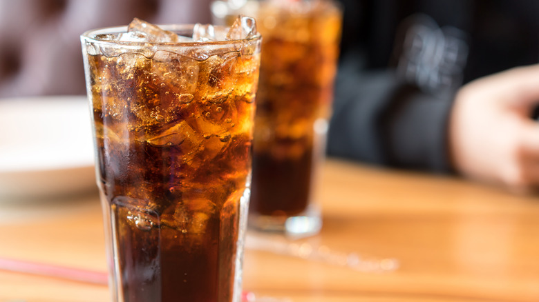 Glasses of soda with ice on a table at a restaurant