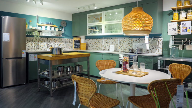 A teal-colored display kitchen in an Ikea store.