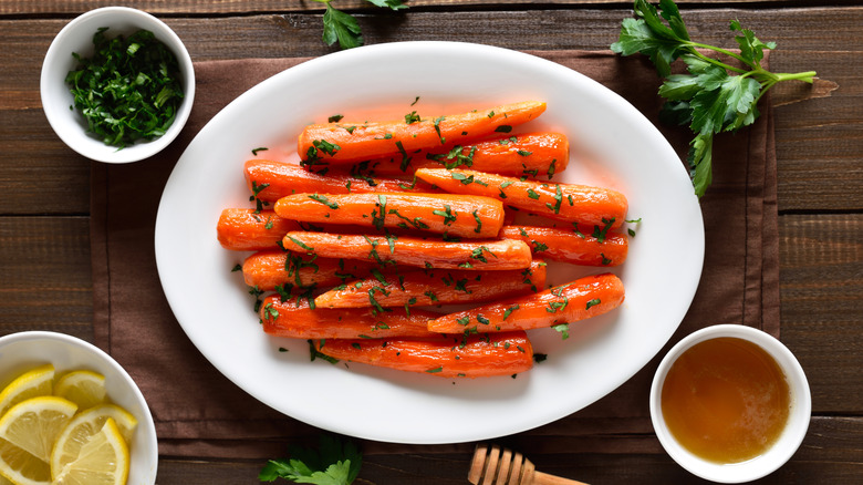 Glazed carrots sprinkled with herbs on a white plate