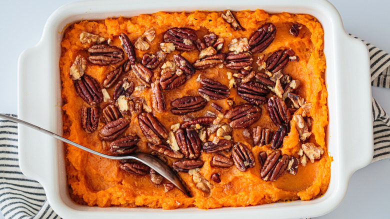 Traditional sweet potato casserole with pecan, top view, white background. Holiday recipe.