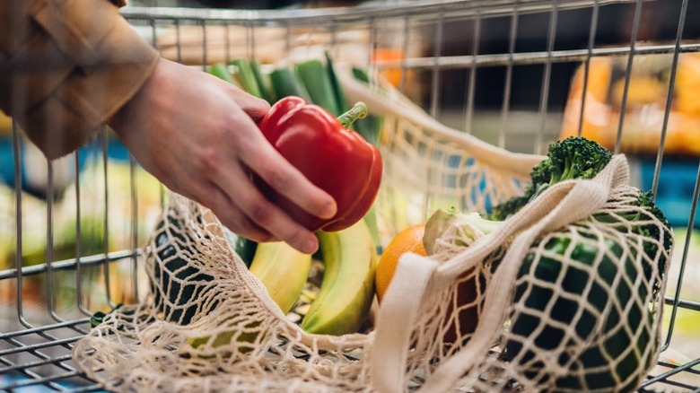 Putting produce in bag while shopping