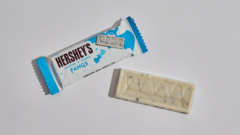 Cookies'n'creme chocolate bar next to a chocolate bar on table