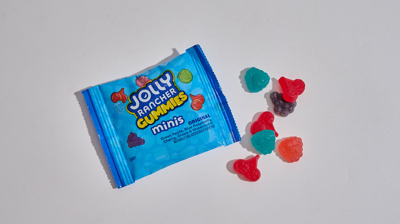 Small package of Jolly Rancher Gummies Minis next to a few gummies on a table
