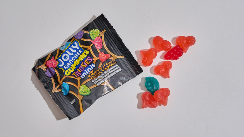 Jolly Rancher Trickies Gummies package next to a handful of gummies on a table