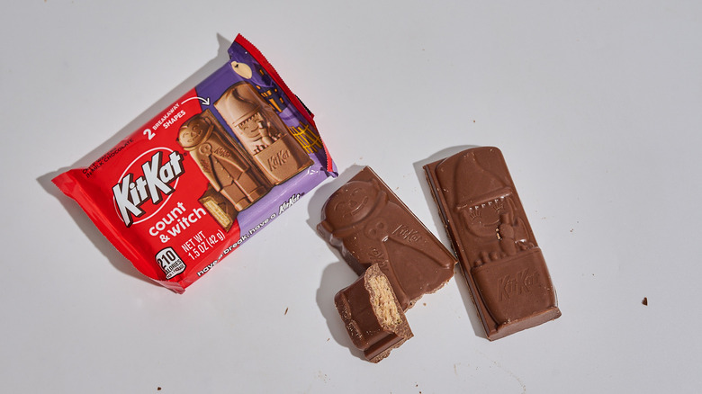 A package of KitKat Count and Witch Milk Chocolate Snack-Sized Bars on a table next to unwrapped KitKats