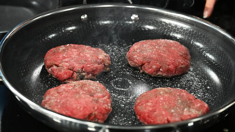 Burgers cook in a HexClad pan.
