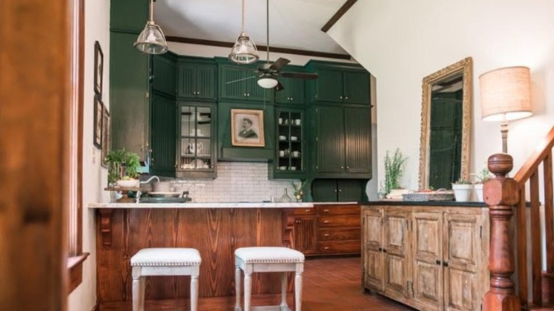 A kitchen designed by Erin Napier with green cabinets and several vintage elements
