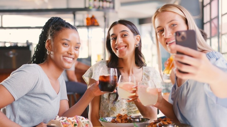 Three friends taking a selfie while dining out