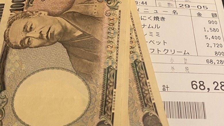 A cash Japanese yen tip with a restaurant check