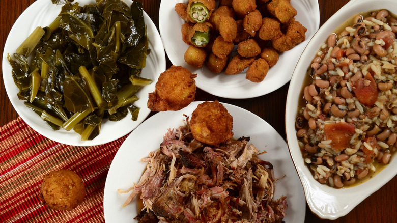 Spread of Southern food, including collard greens, hushpuppies, pulled pork, and rice and beans