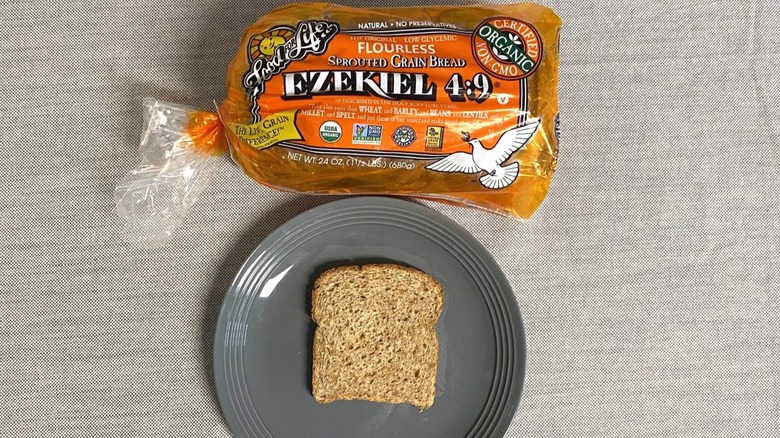 Bag of Food For Life Ezekiel 4:9 Sprouted Grain Bread beside a slice on gray plate